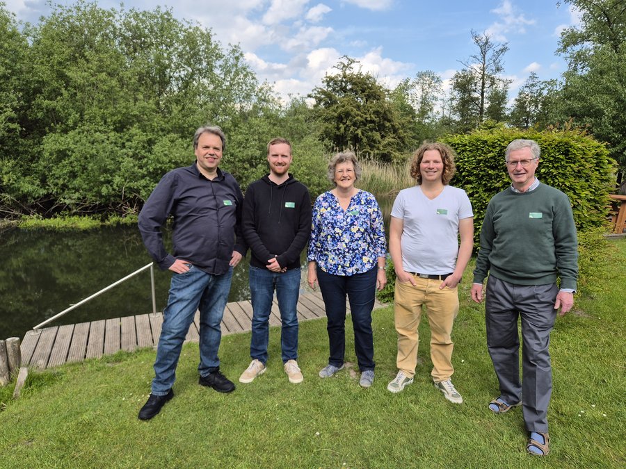 Gruppenbild des Vorstandes der Grünen Bad Oldesloe, fünf Personen auf einer Wiese vor einem Fluss